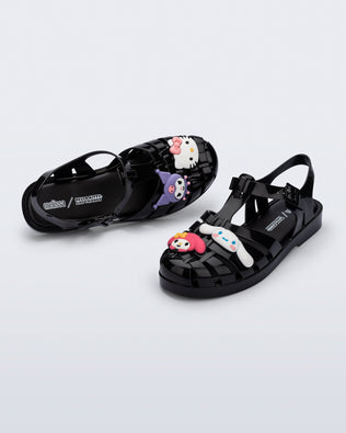 Top and angle view of a pair of black Possession + Hello Kitty and Friends fisherman sandals with Hello Kitty and friends on the upper
