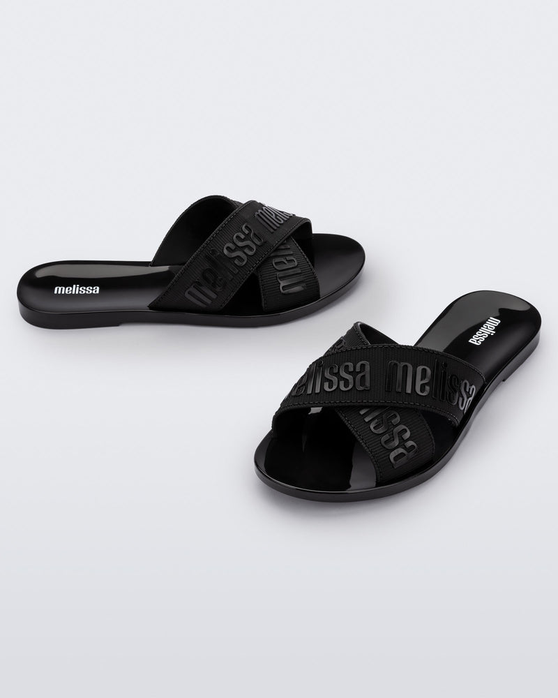 Side and angled view of a pair of black M Lover adult slides