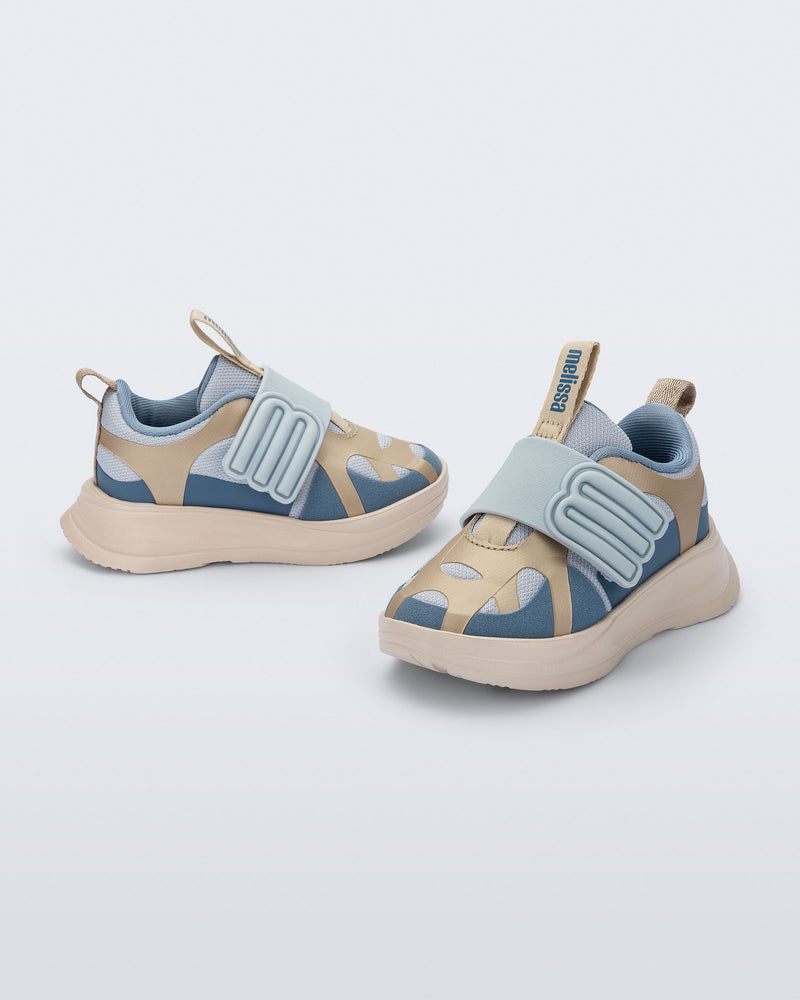 Side and angled view of a pair of blue X Beat baby sneakers with beige trim