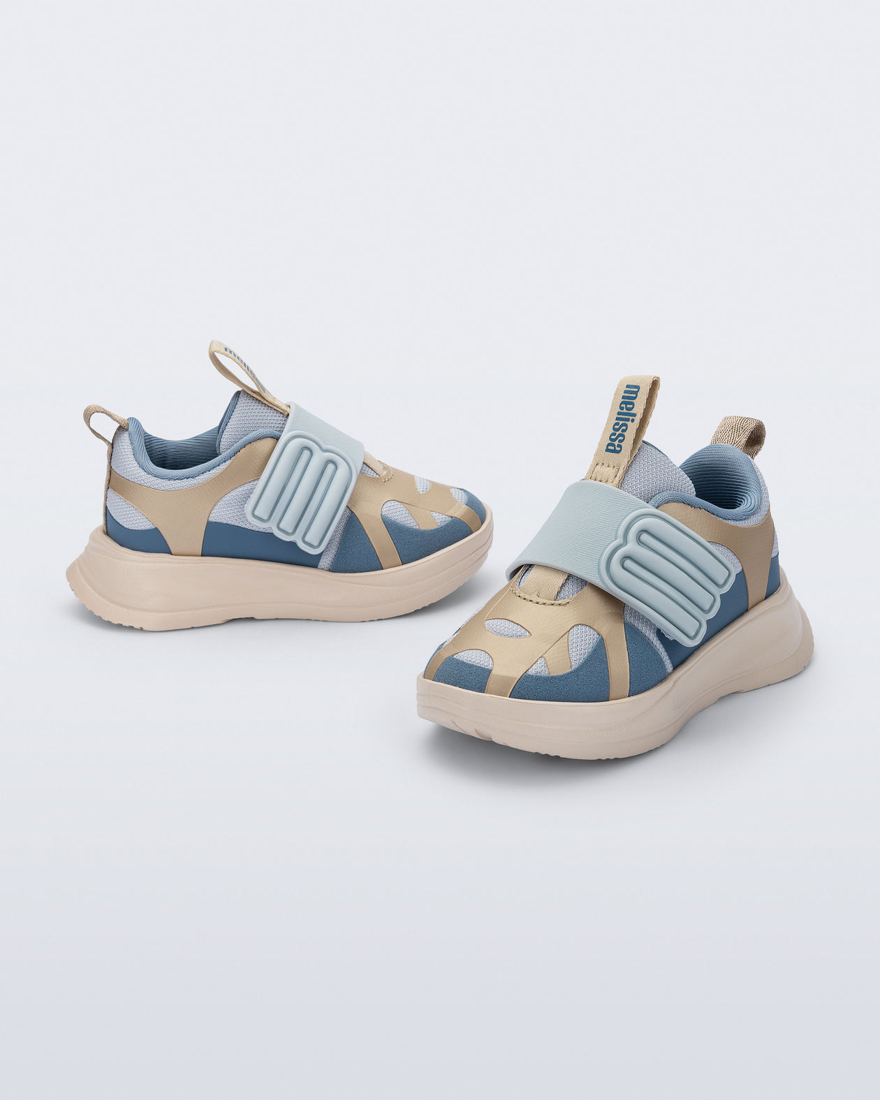 Side and angled view of a pair of blue X Beat baby sneakers with beige trim