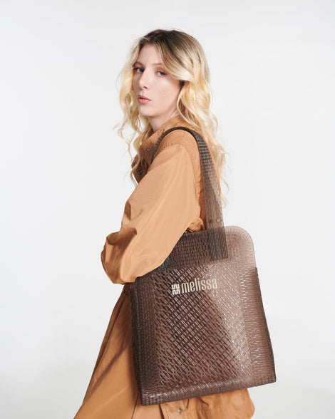 Model in a beige outfit with an brown Harper bag on her shoulder