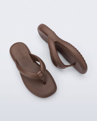 Side and top view of a pair of bronze Free Low flip flops