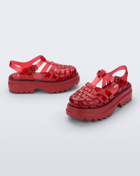 Angled and side view of a pair of transparent red Possession Platform II sandals