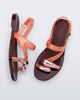 Top and side view of a pair of orange Iris sandals with burgundy sole and rose gold upper embellishments