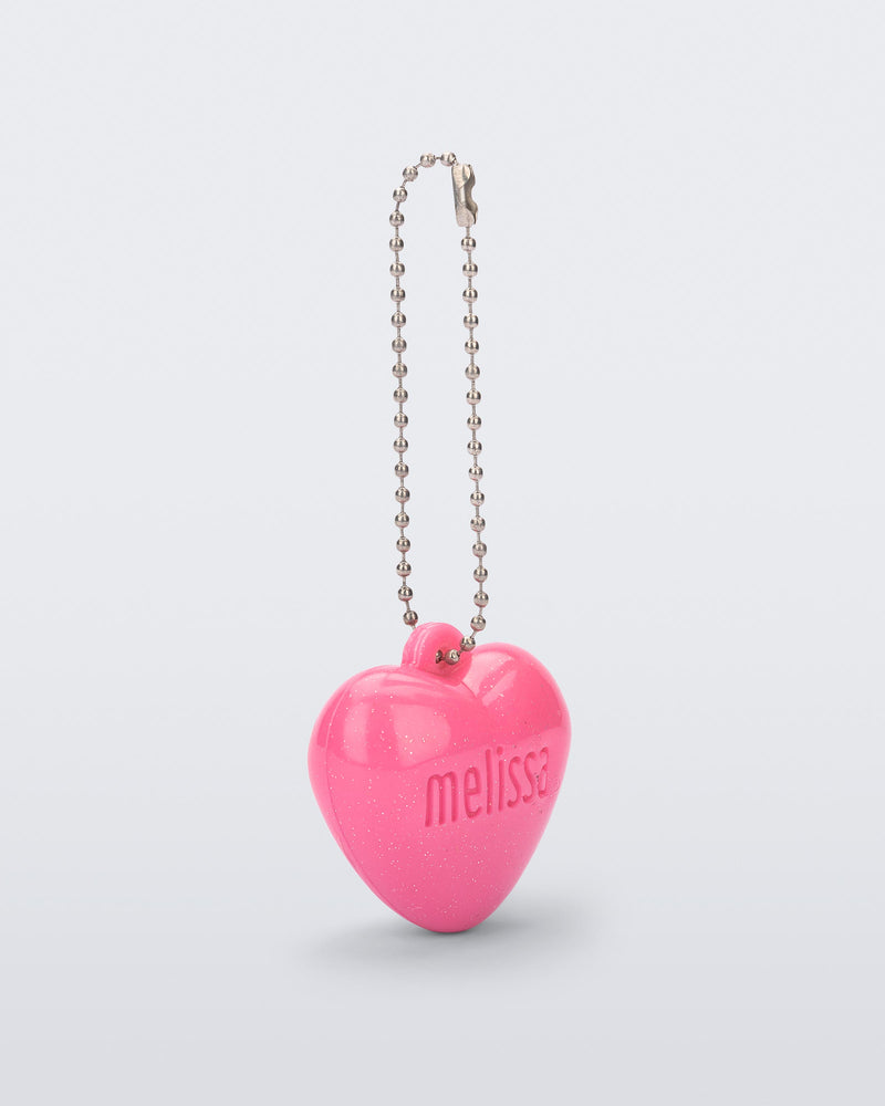 Angled view of a pink Heart Charm with the word Melissa engraved