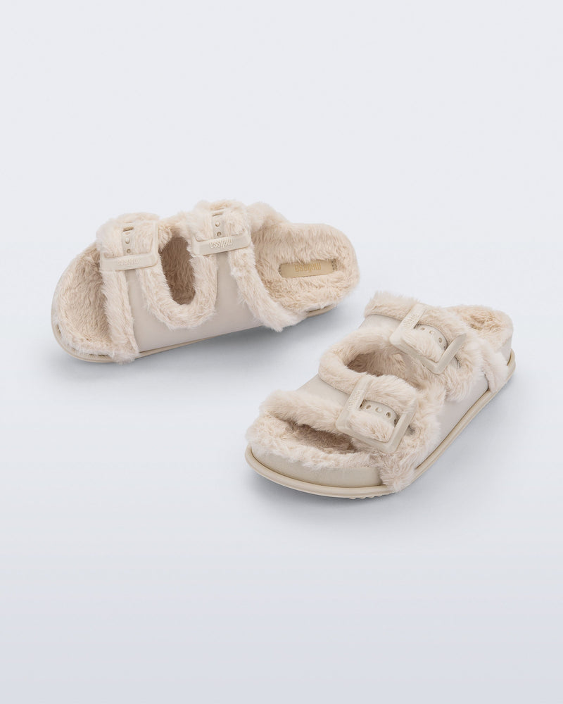 Top and angled view of a pair of beige Cozy Warm Slides with beige fuzzy insoles