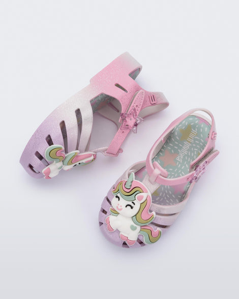 Top and side view of a pair of purple/pink Possession Unicorn baby sandals with unicorn on front upper