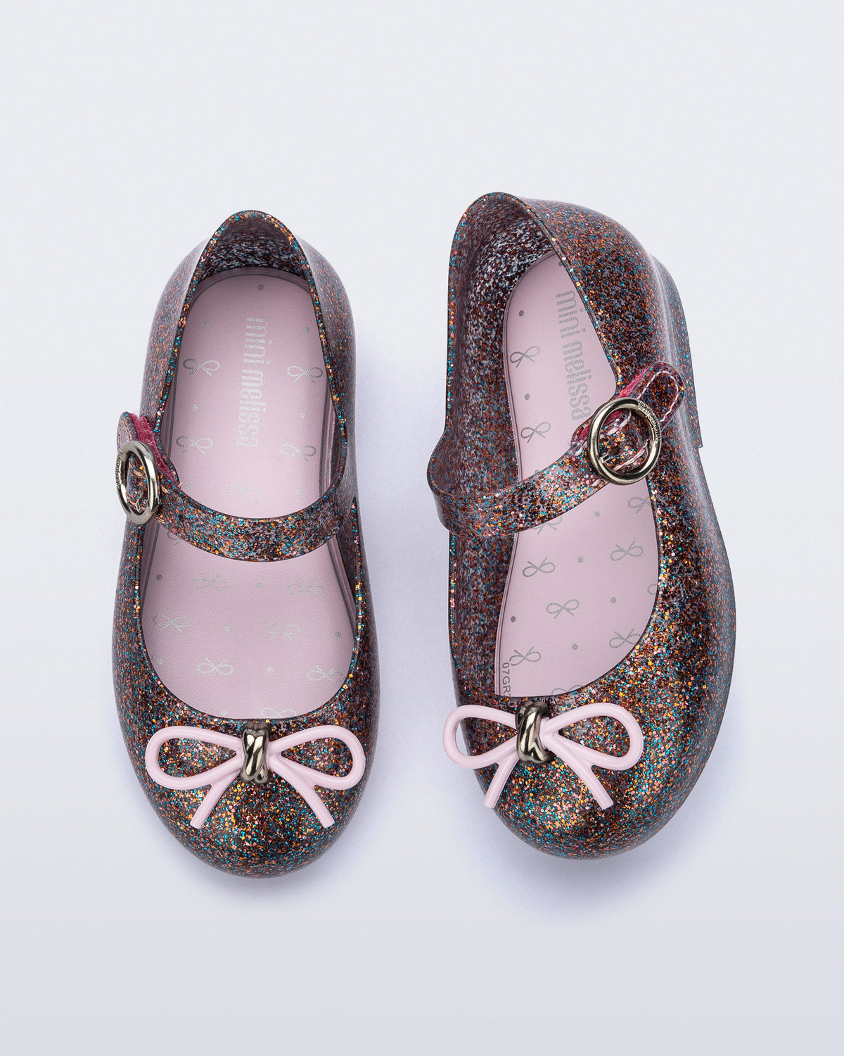 Top and side view of a pair of glitter clear pink baby Sweet Love flats