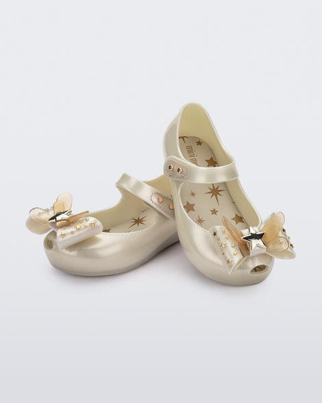 Angled view of a pair of Mini Melissa Ultragirl peeptoe ballet flats for baby in white with star printed butterfly bow applique. 