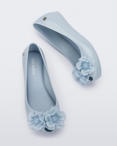 Side and top view of a pair of a blue Ultragirl Springtime kids flat with two blue flowers and peep toe.