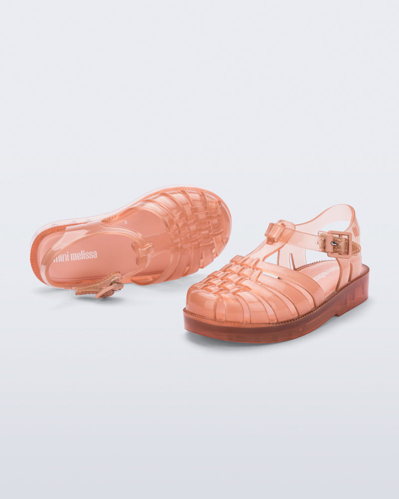 Angled and top view of a pair of clear beige/pink Possession baby sandals