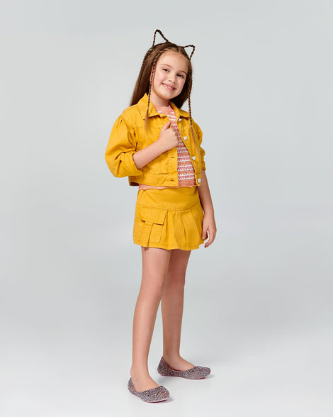 Child model in a yellow outfit wearing a pair of pink multicolor glitter Campana kids flats