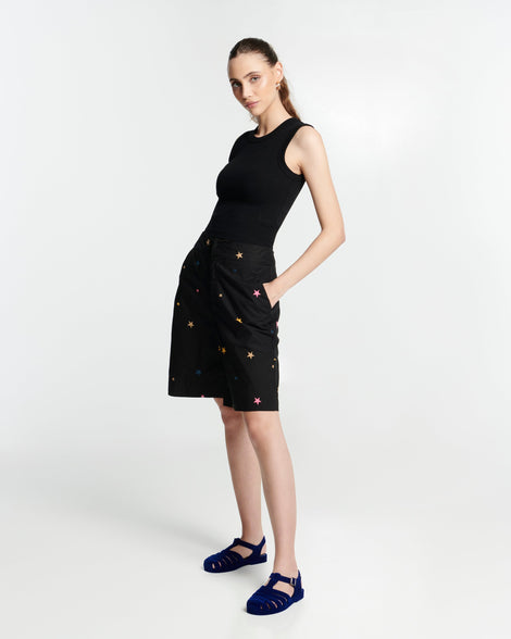 Model in a black dress wearing a pair of flocked blue Possession Velvet fisherman sandals