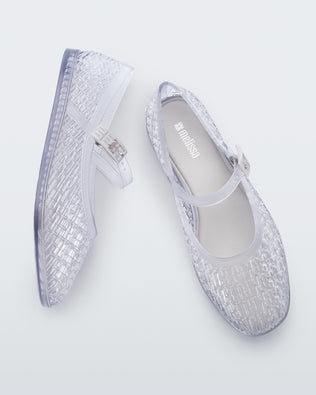 Top and side view of a pair of clear Harper ballet flats with top strap with buckle