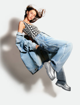 Girl floating in air wearing Marc Jacobs collaboration silver platform clogs.