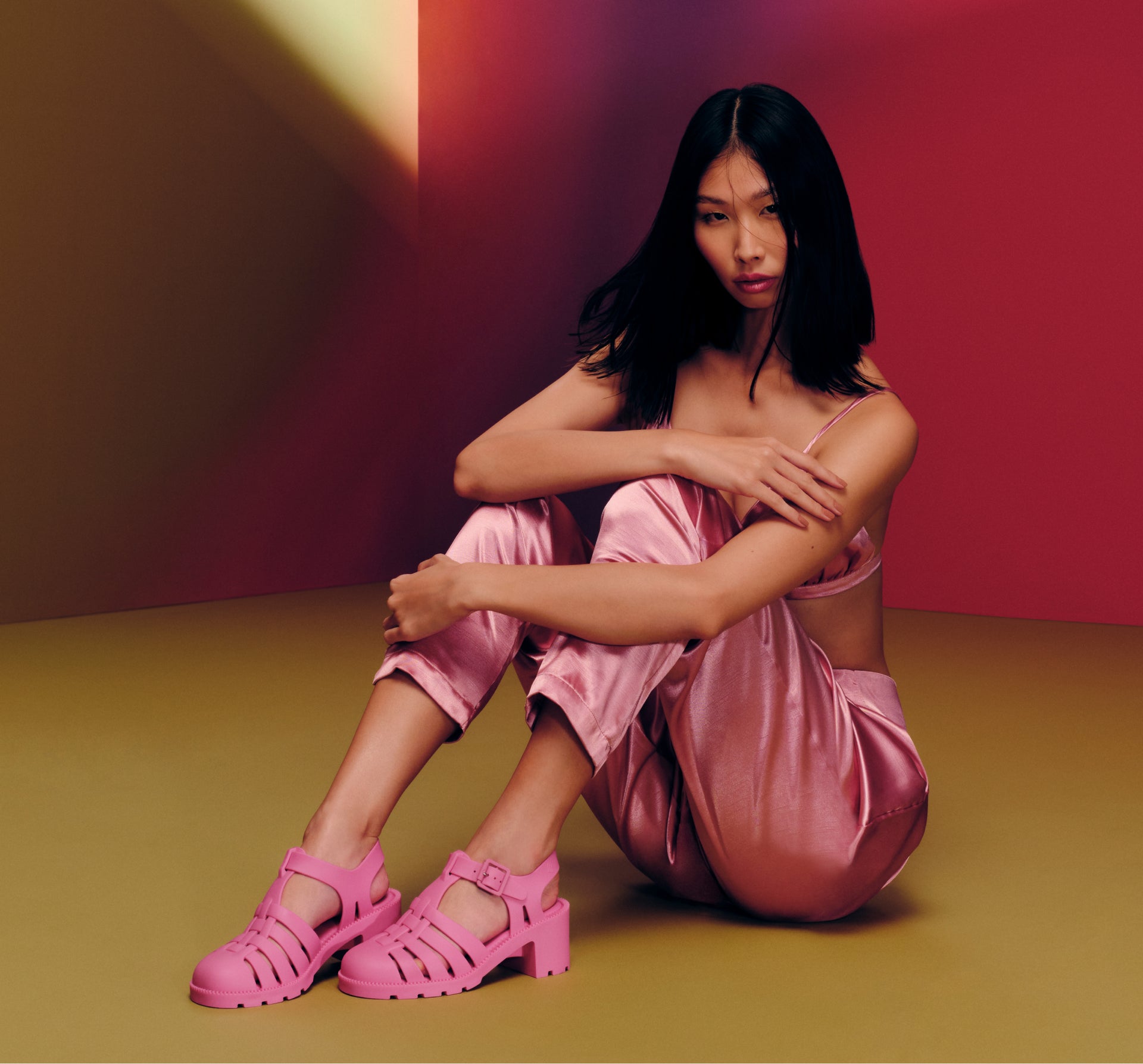 model sitting on floor wearing the pink possession heel