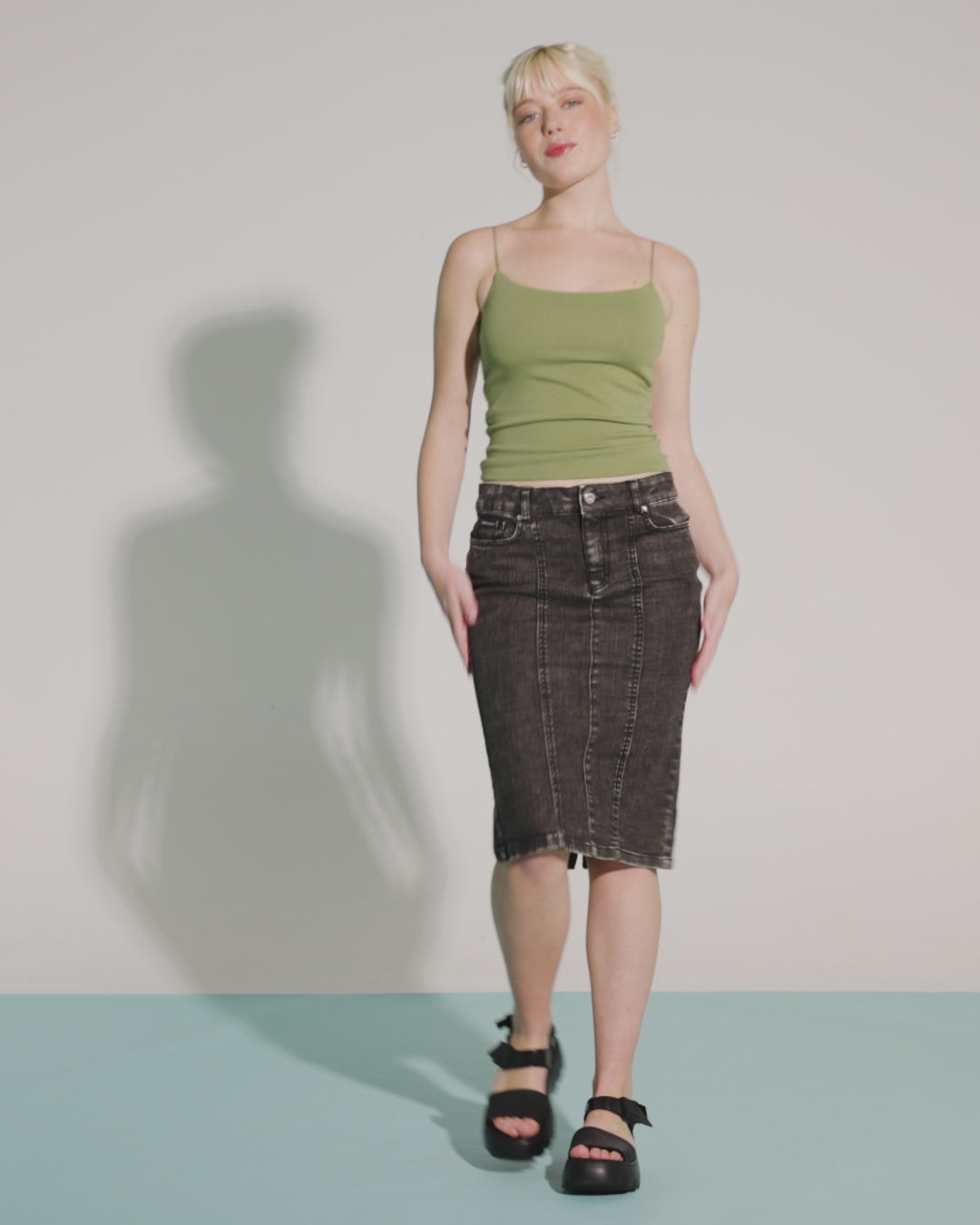 Video with no sound of a model in a green shirt and black skirt wearing a pair of black Kick Off Sandals.