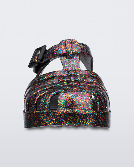 Front view of a Mixed Glitter Glass Mini Melissa Possession sandal with multiple multicolor glitter straps, black buckle and a multicolor glitter sole.