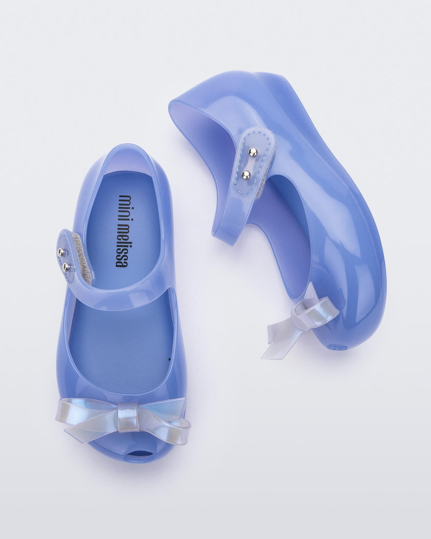 Top and side view of a Blue Mini Melissa Ultragirl Bow flats with a blue base, top strap and white bow detail on the front.