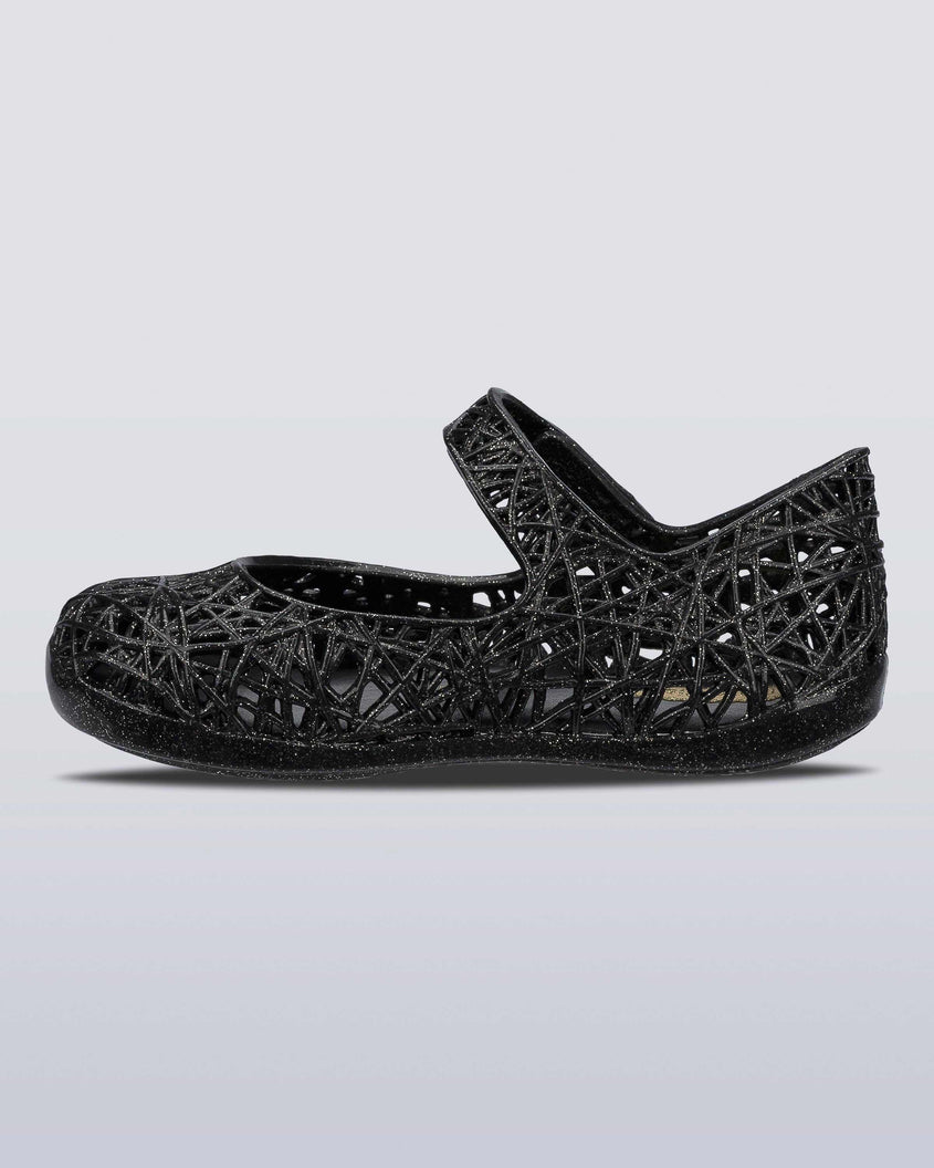 An inner side view of a Black/Silver Glitter Mini Melissa Campana Zig Zag flat with a top strap and a woven detail design.