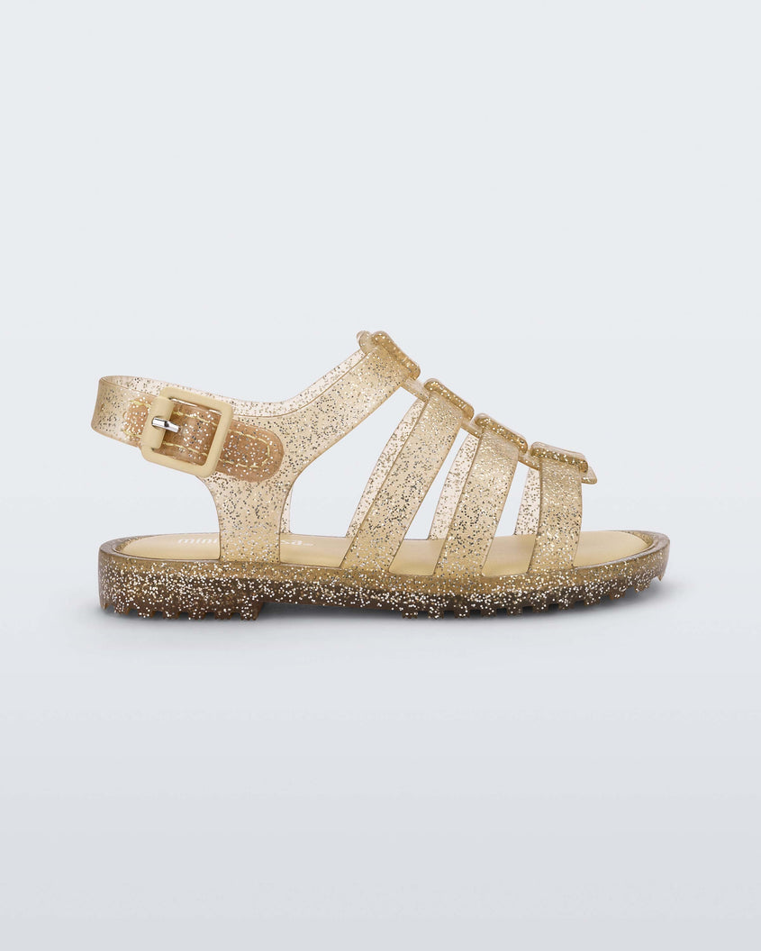 Side view of a clear yellow glitter Mini Melissa Flox sandal with straps.