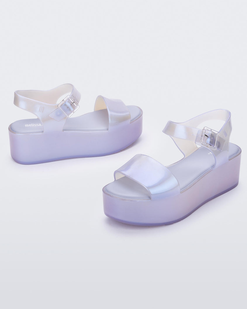 An angled front and side view of a pair of pearly blue Melissa Mar Platform sandals with two straps.