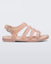 An outter side view of a beige Melissa Flox sandal with straps.