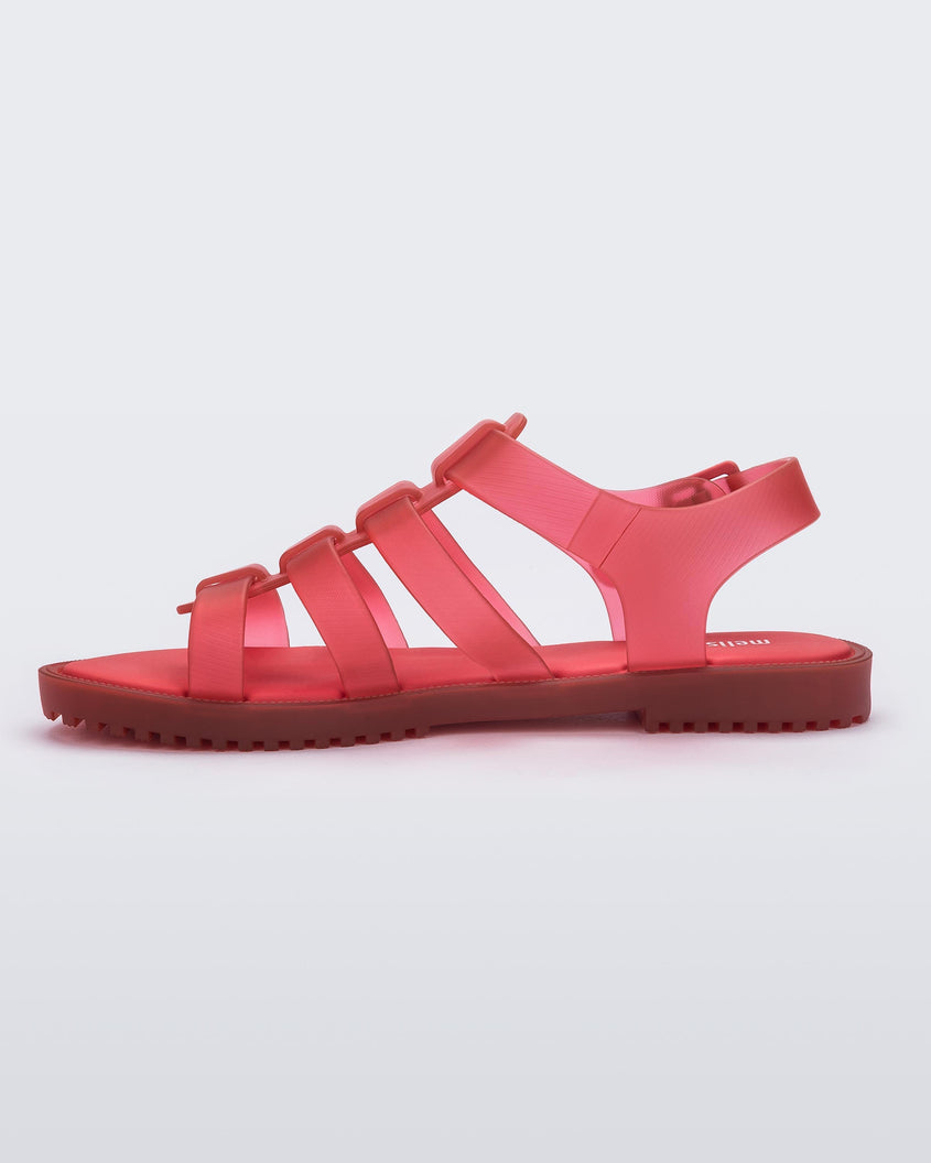 A inner side view of a red Melissa Flox sandal with straps with straps.