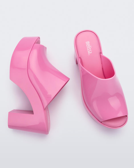 Top and side view of a pair of pink Melissa Mule platform heels.