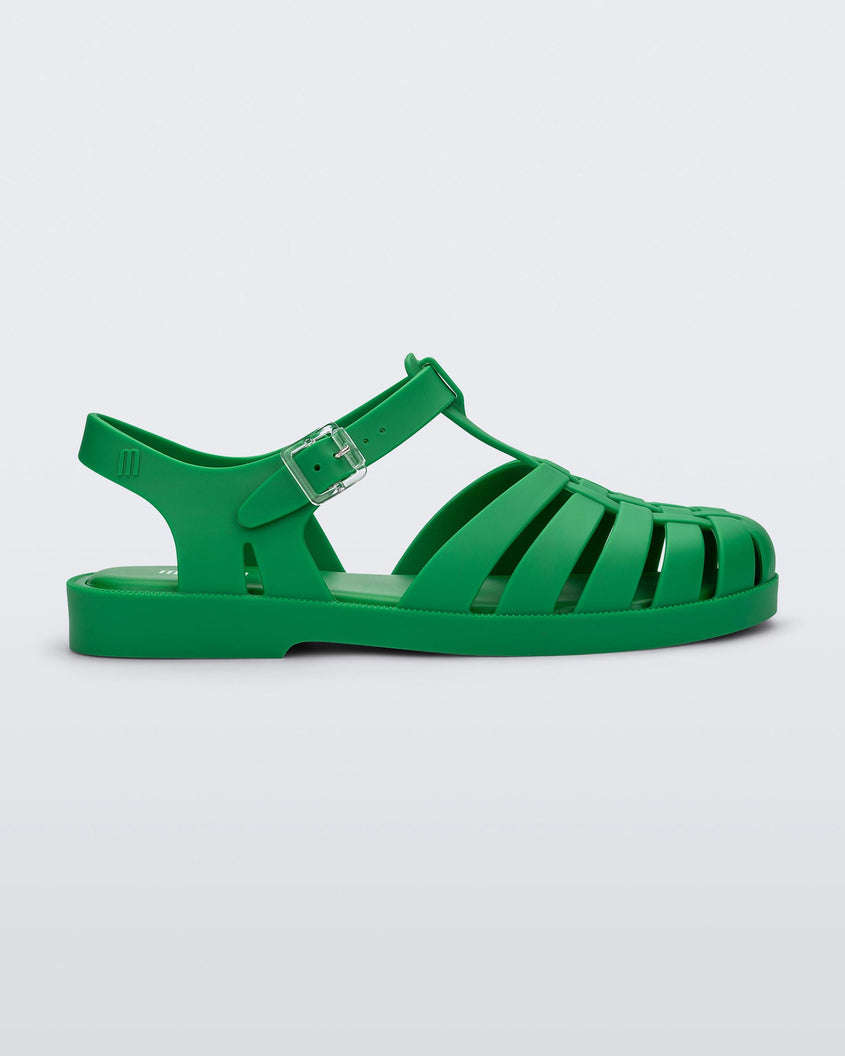 Side view of a green Melissa Possession sandal with a closed toe front weft design connected to a top strap with a buckle.
