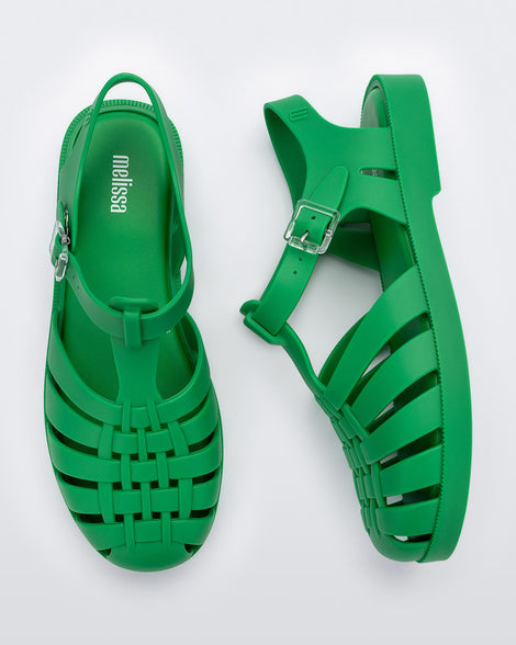 Top and side view of a pair of green Melissa Possession sandals with a closed toe front weft design connected to a top strap with a buckle.