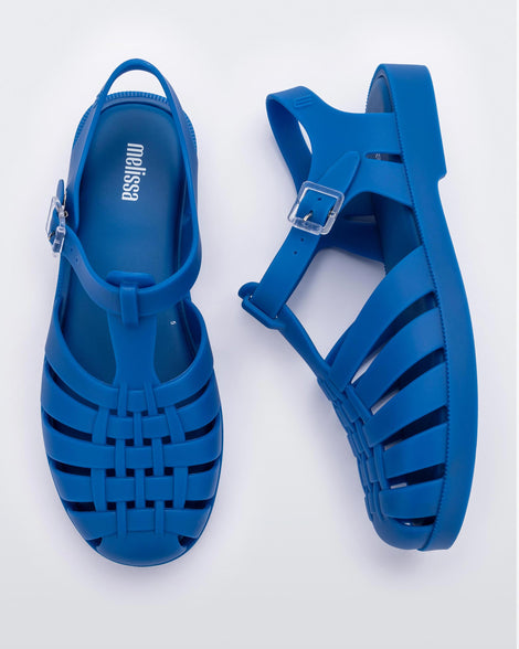 Top and side view of a pair of Melissa Possession fisherman sandals in blue, with cut out fishermen strap detail and clear buckle closure