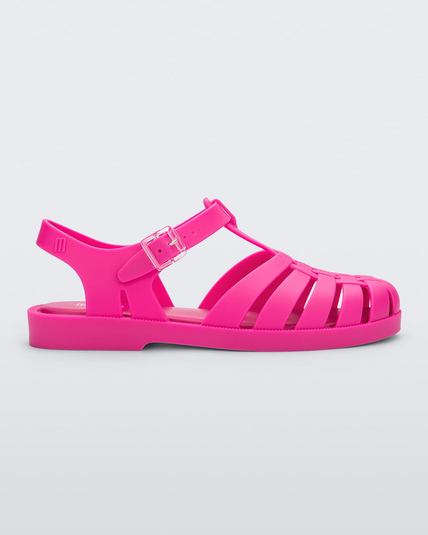 Side view of a pink Melissa Possession sandal with a closed toe front weft design connected to a top strap with a buckle.