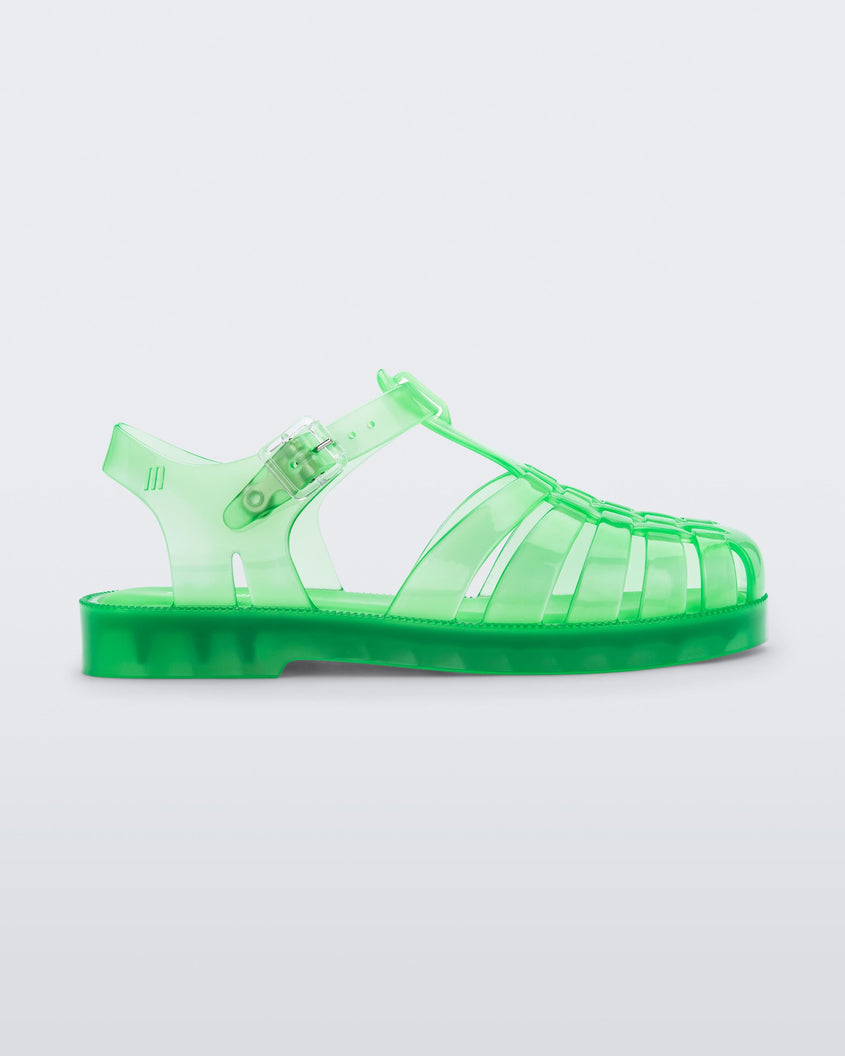 Side view of an clear green Mini Melissa Possession sandal with several straps, a closed toe front and a back ankle strap.