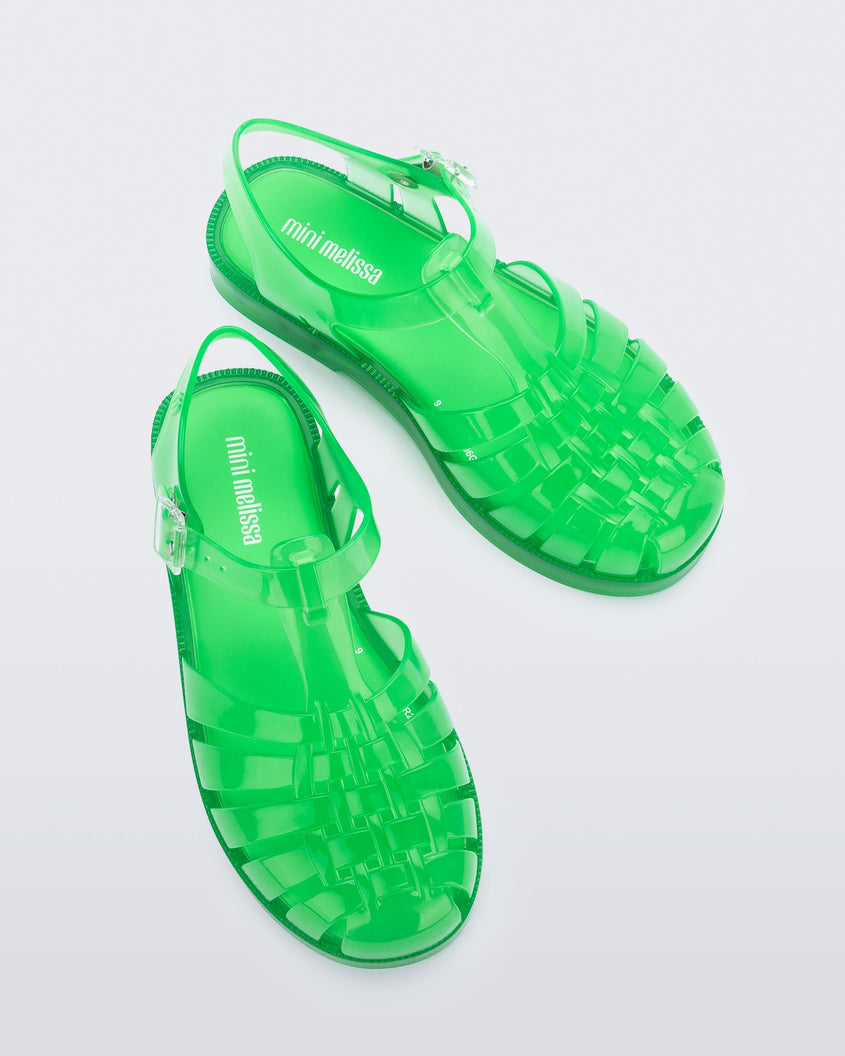 Top view of a pair of clear green Mini Melissa Possession sandals with several straps, a closed toe front and a back ankle strap.