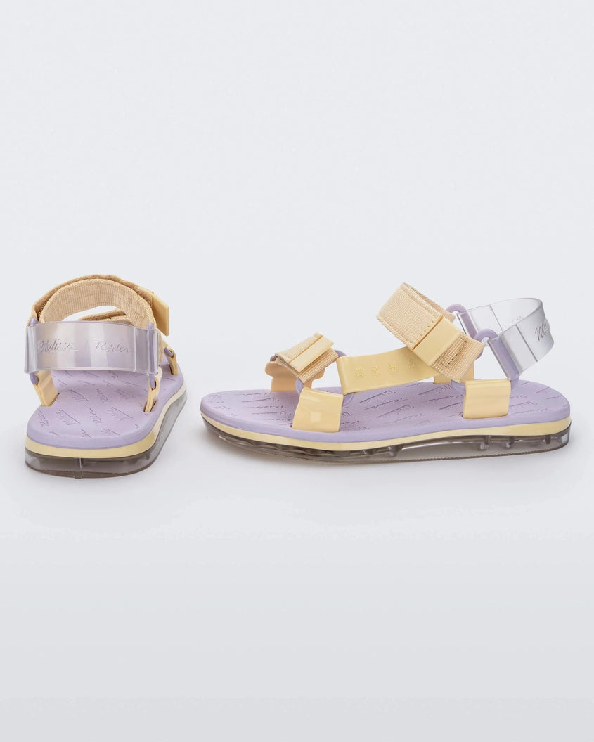 Side and back view of a pair of purple Melissa Papete sandals with yellow and clear purple straps.