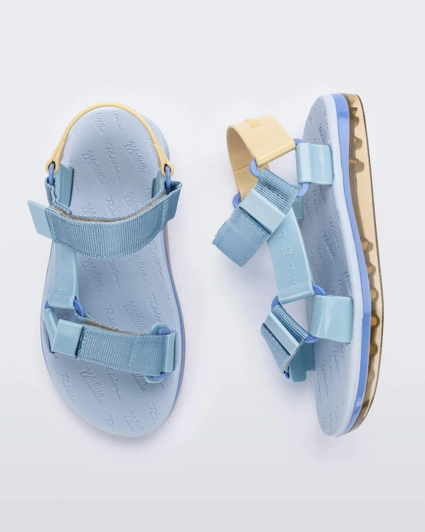 Side and top view of a pair of blue Melissa Papete sandals with blue and beige straps.
