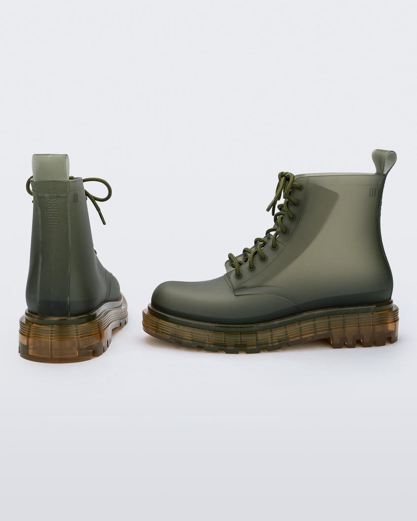 A back and side view of a pair of clear green/yellow Melissa Coturno boots with a green base, laces and a yellow sole.