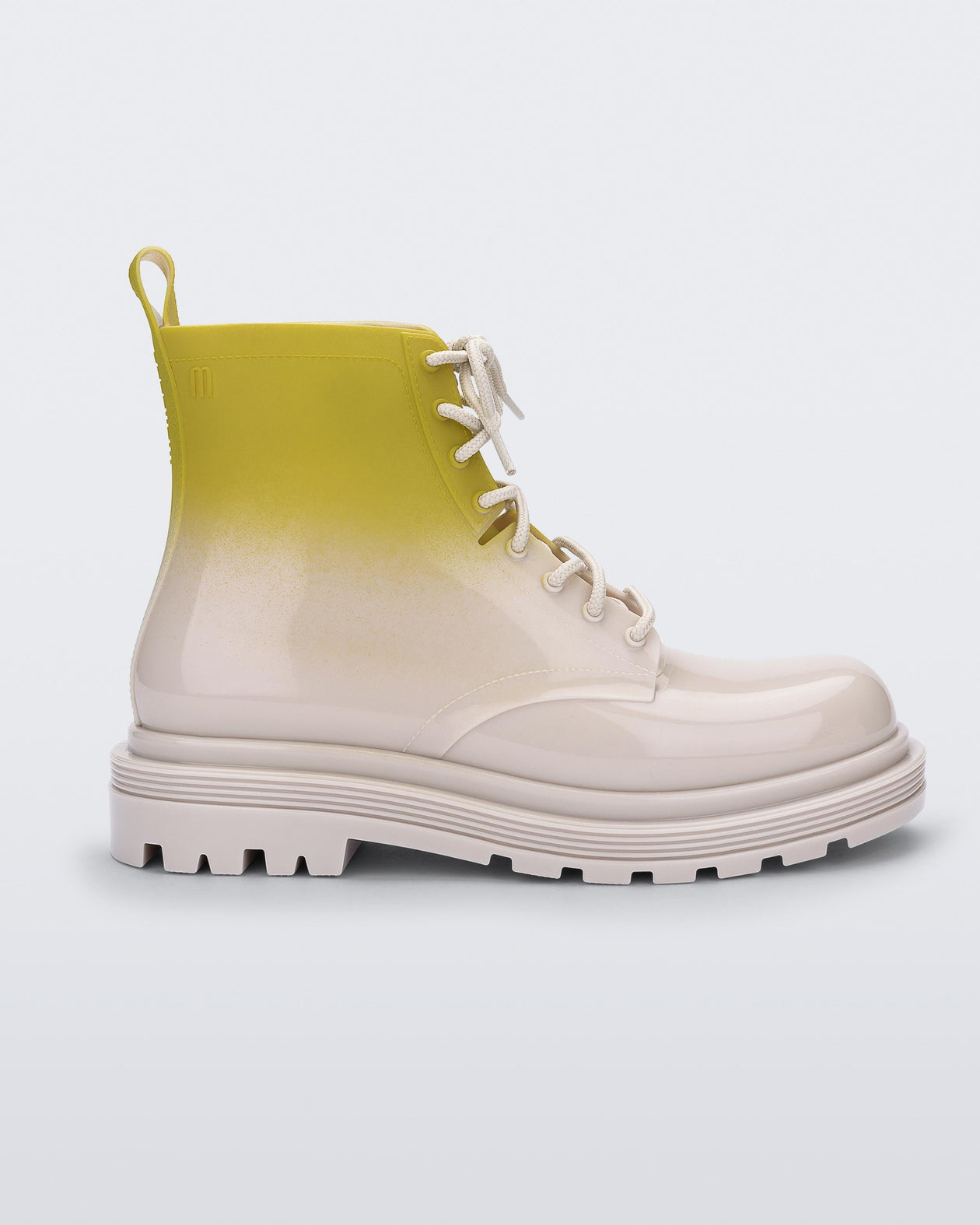Side view of a beige/green Melissa Coturno boot with a green into beige ombre base, beige laces and sole.