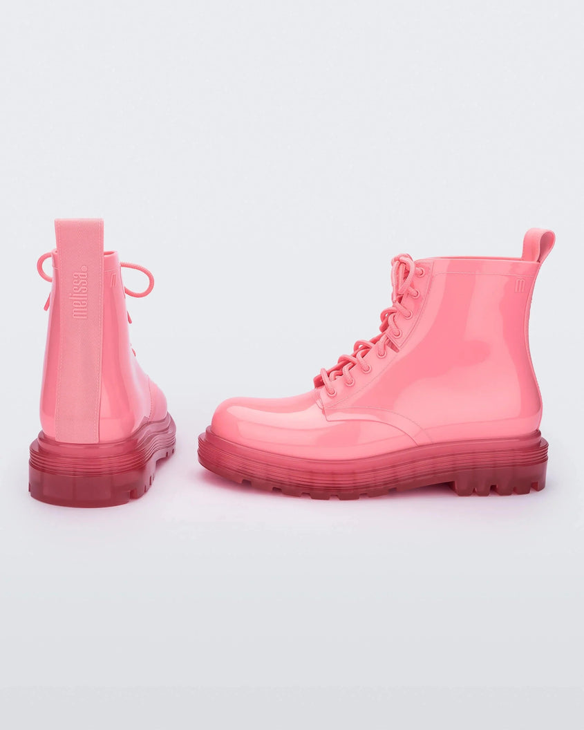 A back and side view of a pair of clear pink/pink Melissa Coturno boots with a pink base, laces and sole.