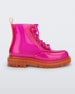Side view of a pair of a clear orange / pink Melissa Coturno boot with a pink base, laces and an orange sole.