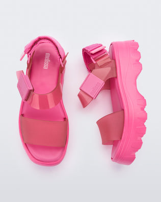 A top and side view of a pair of pink/clear pink platform Melissa Kick Off Sandals with two straps.