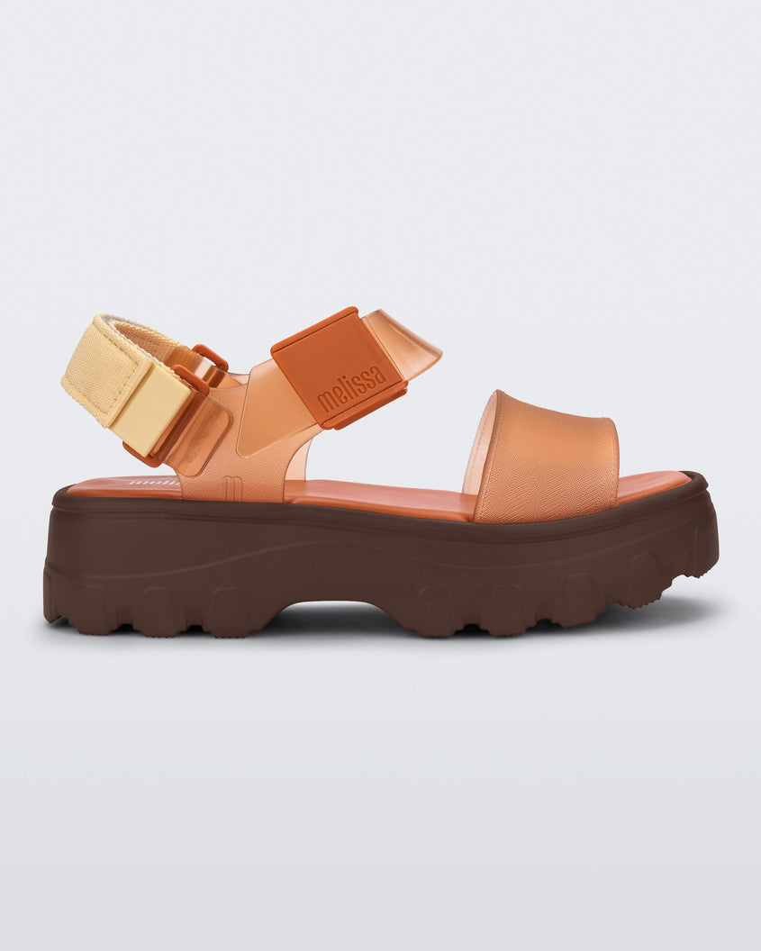 Side view of an orange/clear orange Melissa platform Kick Off sandal with two straps and a brown sole.