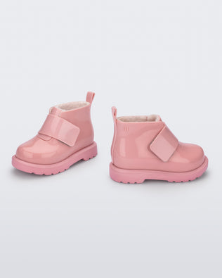 Angled and side view of a pair of pink baby Chelsea boots with faux fur lining