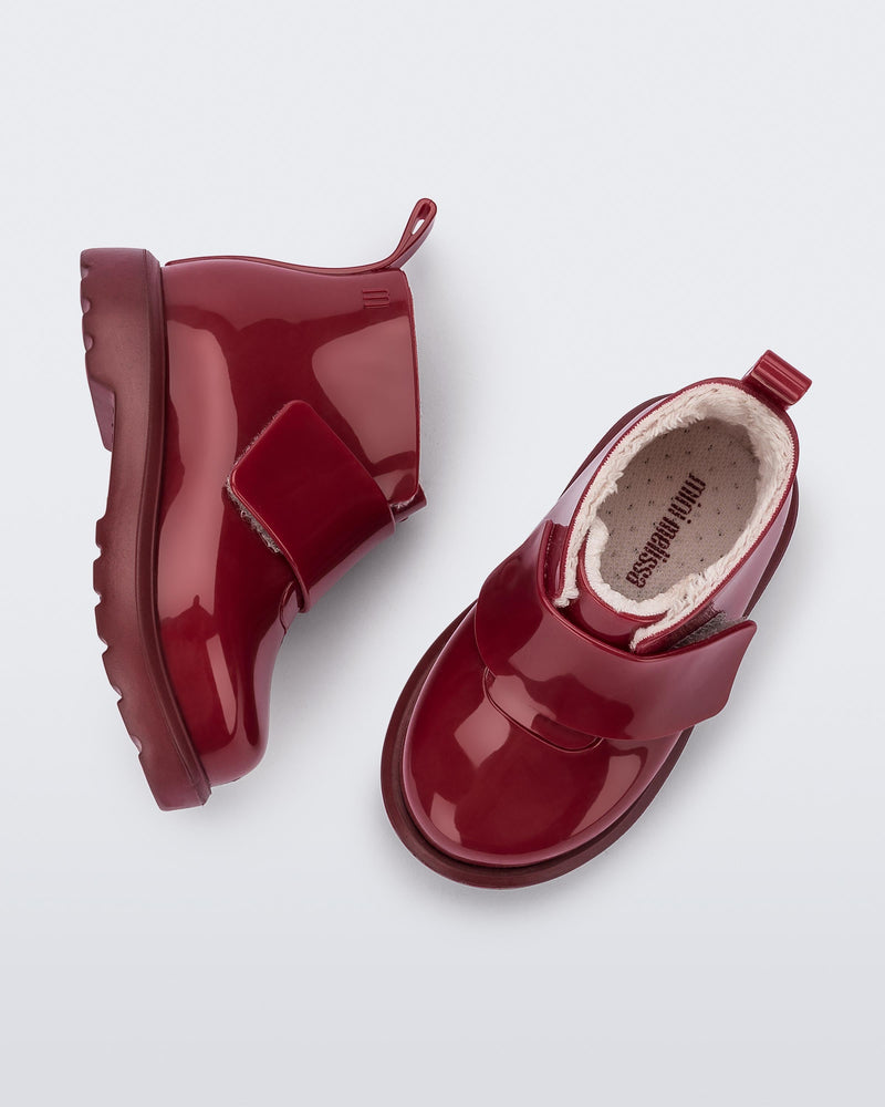 Top and side view of a pair of red baby Chelsea boots with faux fur lining