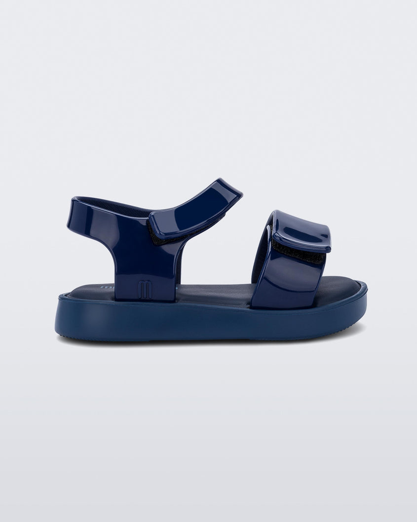 Side view of a blue Mini Melissa Jump sandal with velcro straps.