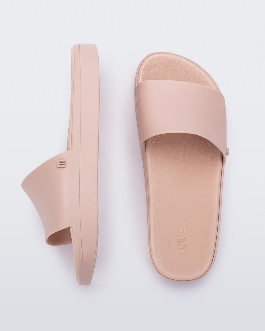 Top and side view of a pair of light pink Melissa Beach slides. 