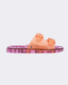 Side view of a Melissa Wide slide sandal with pink sole and two orange front straps
