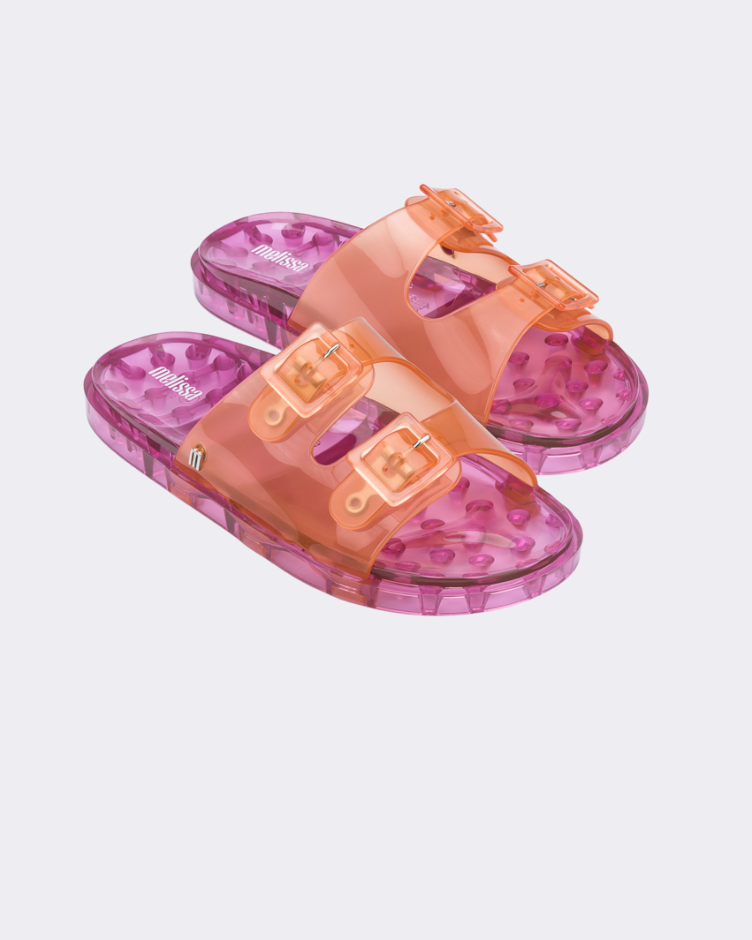 Angled view of a pair of Melissa Wide slide sandals with pink sole and two orange front straps