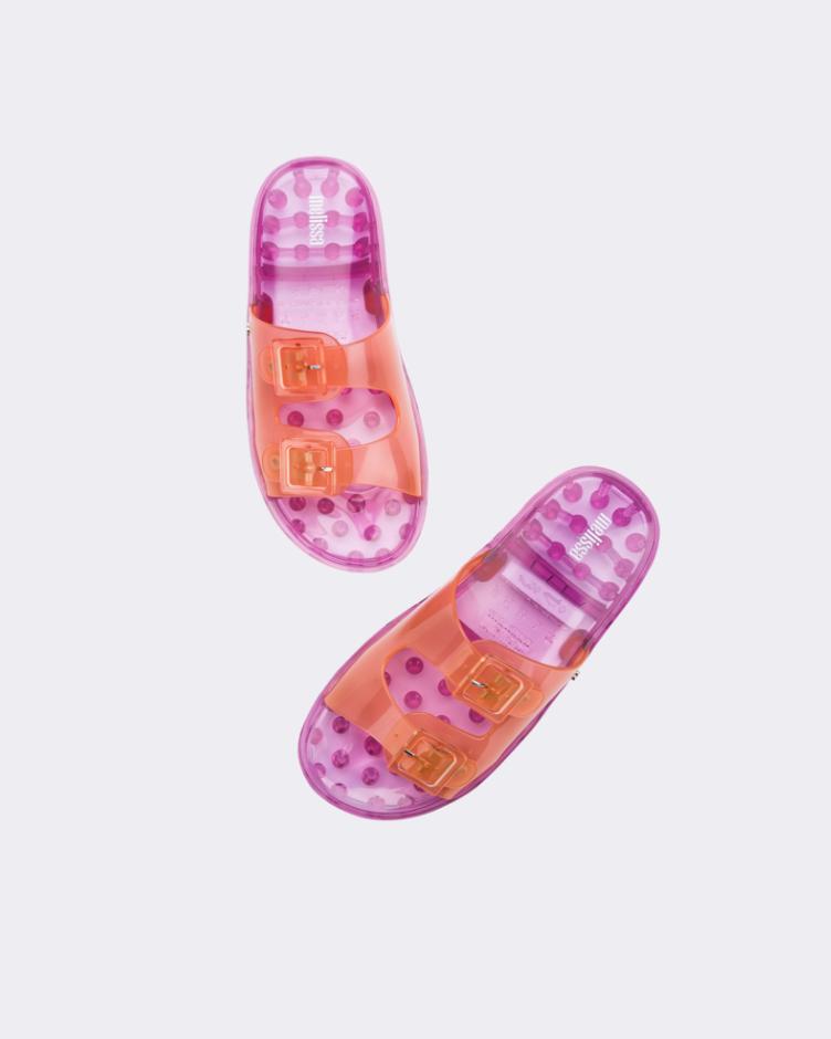 Top view of a pair of Melissa Wide slide sandals with pink sole and two orange front straps